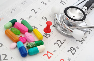 A collection of colorful prescription capsules and a silver medical stethoscope