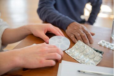 Pharmacist and patient hands discussing mmedications