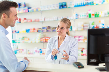 Pharmacist assisting a customer with their prescription