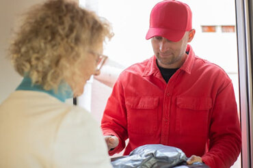 Pharmacy delivery driver dropping off medications to patient at their doorstep